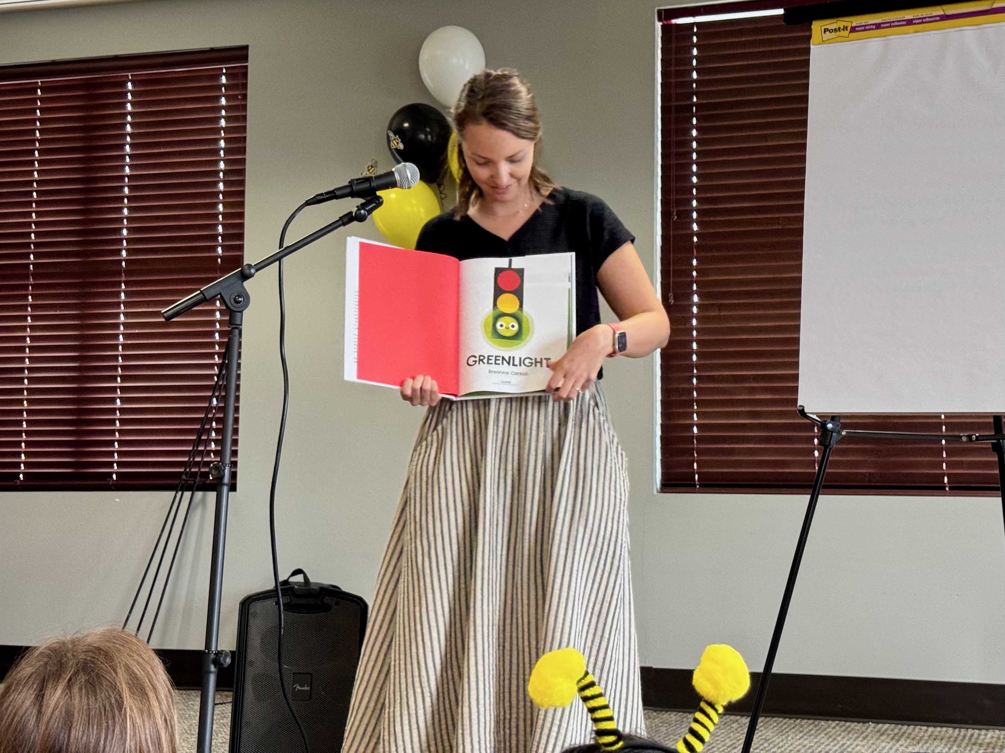 Breanna read Greenlight to a room full of kids wearing bee antennae.